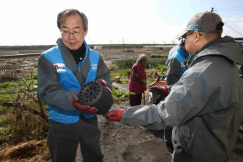 서문규 한국석유공사 사장(왼쪽)이 연탄을 나르고 있다.