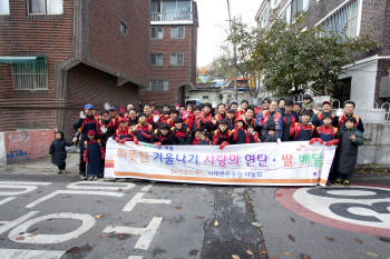 SK브로드밴드 임직원과 가족이 소외이웃에 연탈과 쌀을 전달하고 기념촬영을 하고 있다.