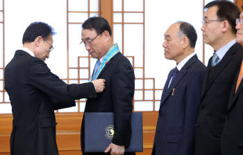 이명박 대통령이 6일 청와대에서 열린 디지털방송 전환 유공자 포상에서 김인규 전 지상파디지털방송추진협의회장(오른쪽 세번째) 등에게 훈장을 수여하고 있다. <연합뉴스>