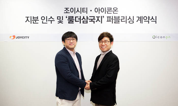 조한서 조이시티 상무(왼쪽)와 송진우 아이콘온 대표가 전략적 지분 인수 및 `룰더삼국지` 퍼블리싱 계약을 체결하고 악수를 나누고 있다.