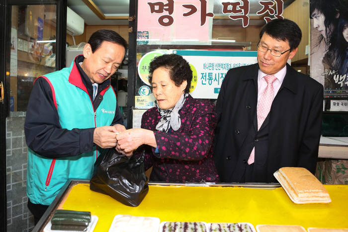 정수진 하나은행 부행장(왼쪽)과 김영수 송파구 부구청장(오른쪽)이 새마을 시장에서 쿠폰북 마케팅 활동을 벌이고 있다.