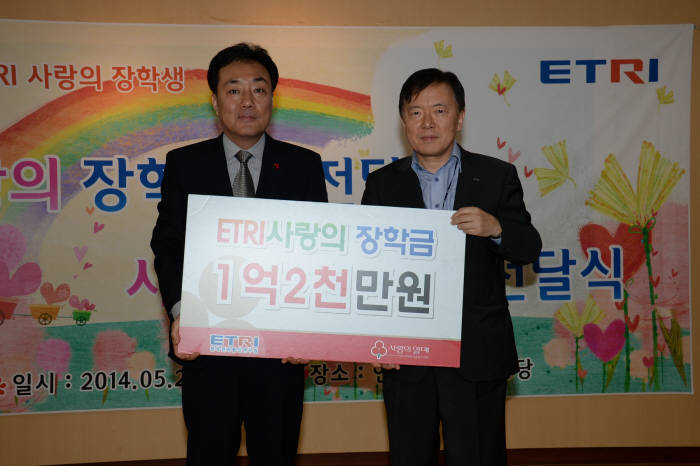 황춘식 ETRI 경영관리본부장(오른쪽)이 황후영 대전사회복지공동모금회 사무처장에게 장학금을 전달한 후 기념촬영했다.