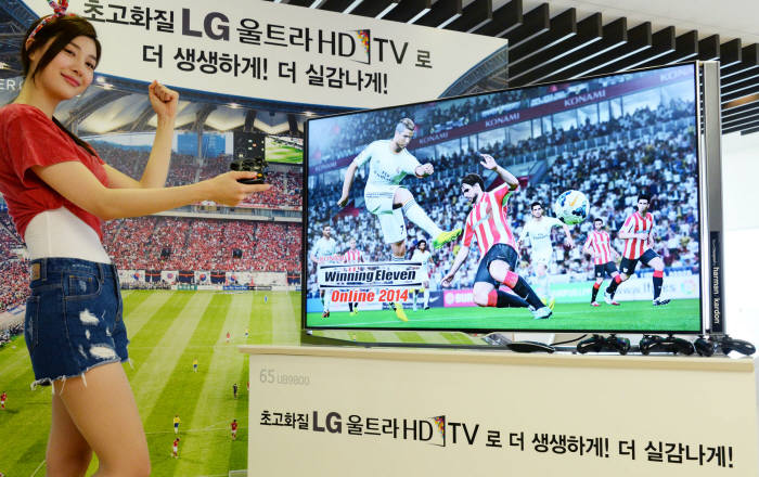 LG전자는 지난달부터 UHD 화질로 즐기는 `위닝일레븐 2014` 축구리그를 개최하고 있다. LG 모델이 LG UHD TV와 함께 포즈를 취하고 있다.