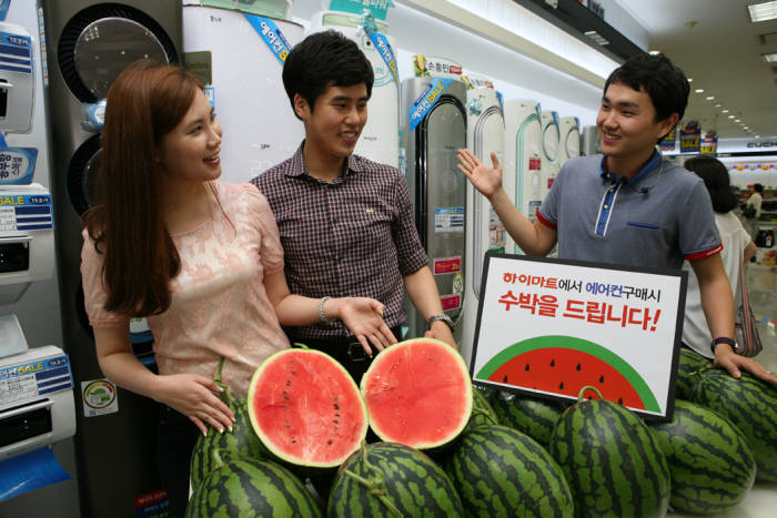 하이마트 대치점을 방문한 고객이 전문상담원의 설명을 들으며 에어컨과 증정용 수박을 살펴보고 있다.