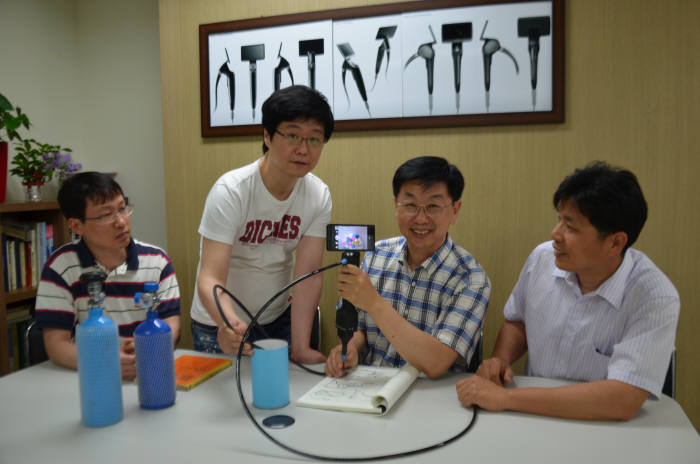 옵티메드는 교차 감염 우려가 없는 일회용 내시경 `클린스코프`를 개발했다. 김현태 옵티메드 대표(왼쪽에서 세번째)가 클린스코프를 들고 시연하고 있다.