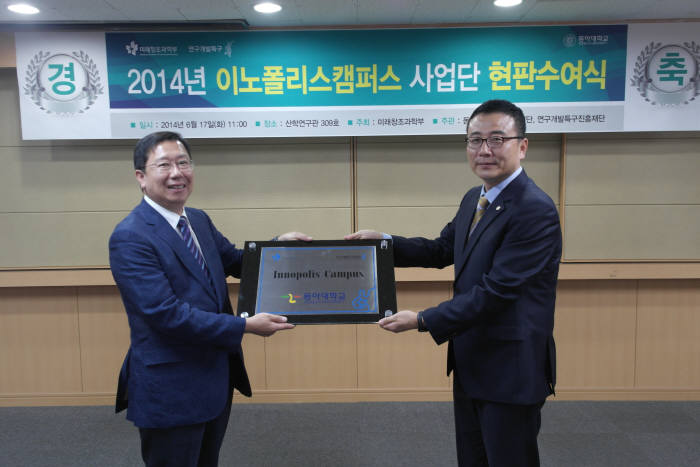 오영환 부산연구개발특구본부 본부장(오른쪽)이 김동규 동아대 산학협력단장에게 이노폴리스캠퍼스 현판을 수여하고 있다.