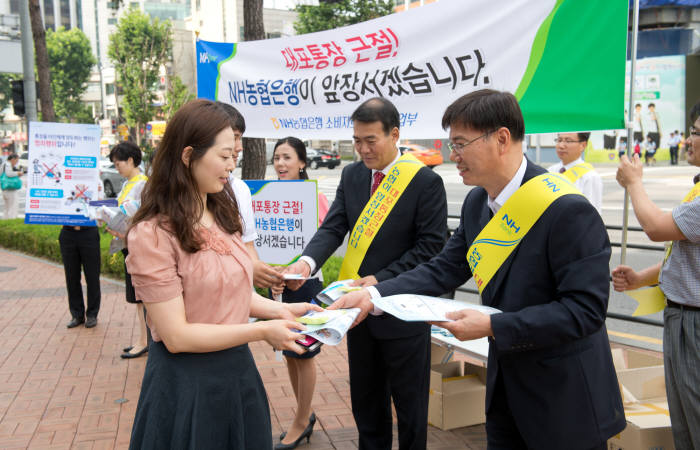 김기해 소비자보호부장(오른쪽) 과 오경석 영업부장(오른쪽 두번째)이 금융소비자 보호를 위한 전단지를 나눠주며 안내하고 있다.