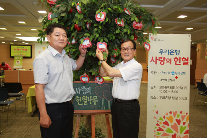 이순우 우리은행 행장(오른쪽)과 박원춘 노조위원장이 우리은행 본점에서 열린 `사랑의 헌혈` 캠페인에 참여해 헌혈 후 헌혈증을 기증하고 있다.