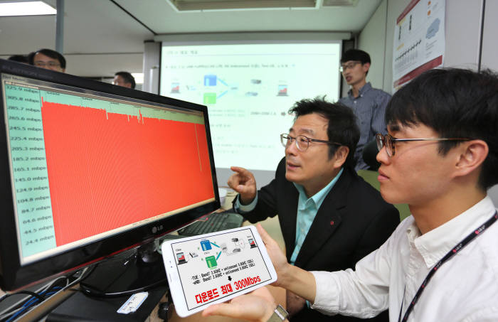김선태 LG유플러스 서비스개발(SD) 본부장(가운데)이 서울 금천구 독산사옥에서 LTE-U 기술 시연을 참관하고 있다..