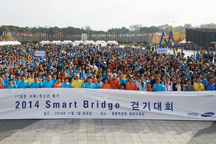 `행복송파 구민건강걷기대회`와 함께 진행된 `2014 스마트 브릿지 걷기대회`에 참여한 삼성SDS 직원과 송파구민들이 기념촬영했다.