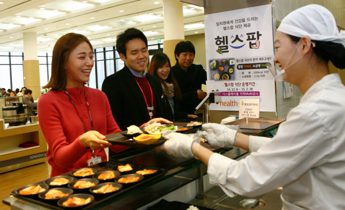 삼성디스플레이 임직원들이 점심시간을 맞아 사내식당에서 제공하는 저염 건강식을 먹기 위해 줄을 서서 기다리고 있다.