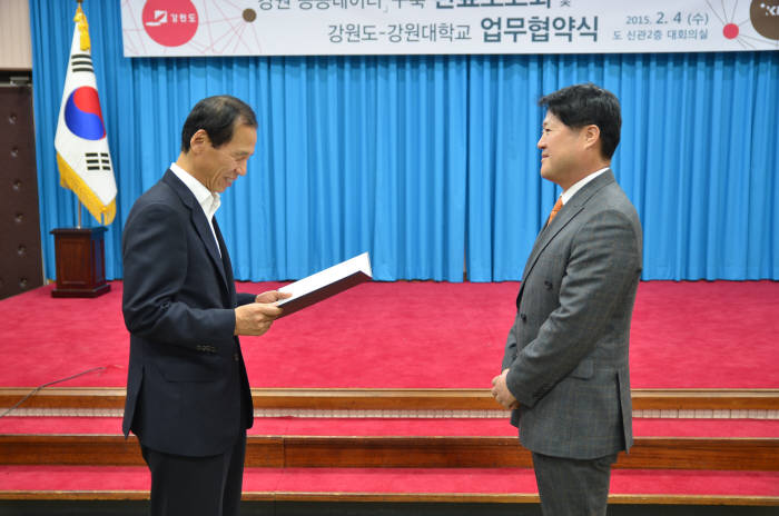 최문순(왼쪽) 강원도지사가 김종현 위세아이텍 대표에게 업무 협약 증서를 전달하고 있다.