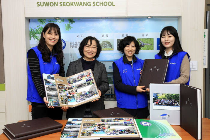 수원서광학교 한정애 교장에게 삼성SDI 임직원들이 졸업앨범을 전달했다.