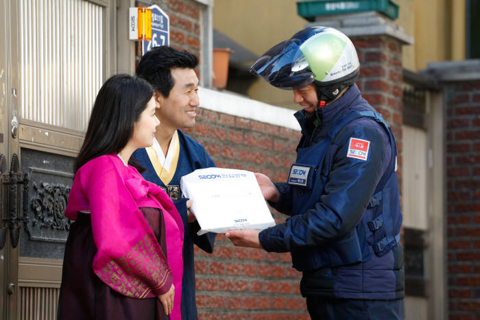 에스원 출동요원이 설 연휴 기간 동안 가정으로 배달된 물품을 수거해 별도 보관해온 안심봉투를 고객에게 전달하고 있다.