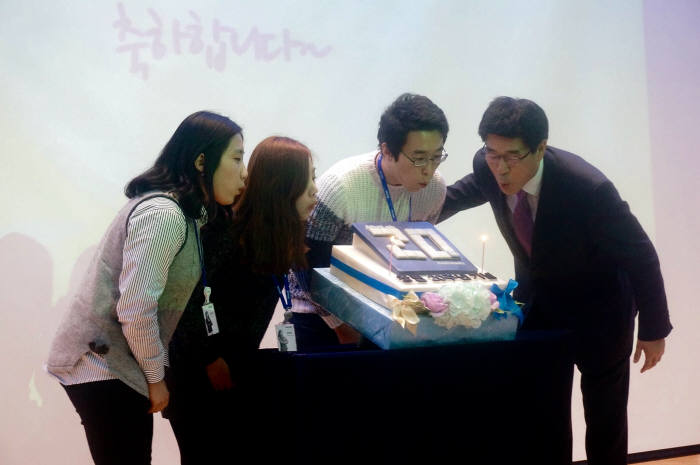 권치중 대표(맨 오른쪽)와 직원들이 20주년 기념 케익에 촛불을 함께 끄고 있다.