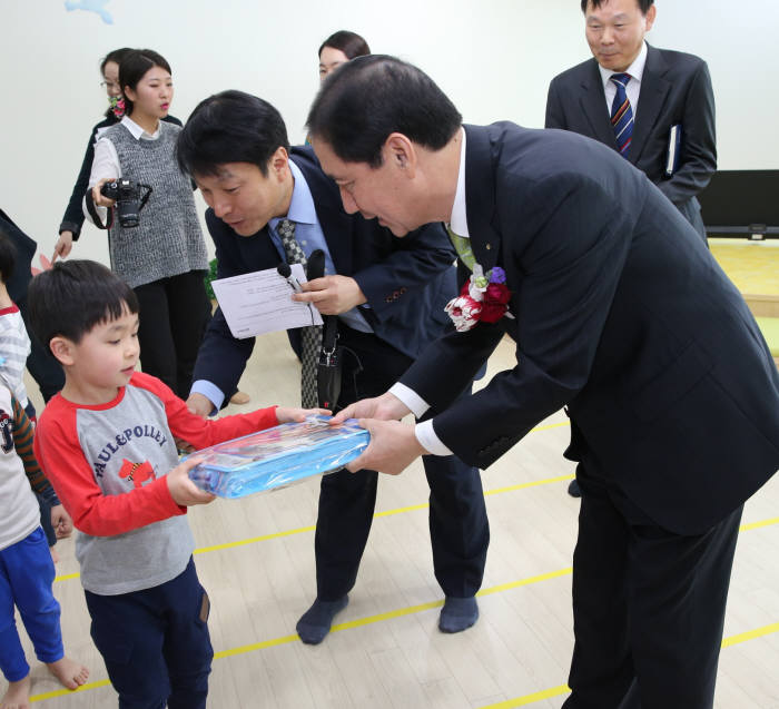 전병일 대우인터내셔널 사장이 어린이집 임직원 자녀에게 축하 선물을 전달하고 있다.