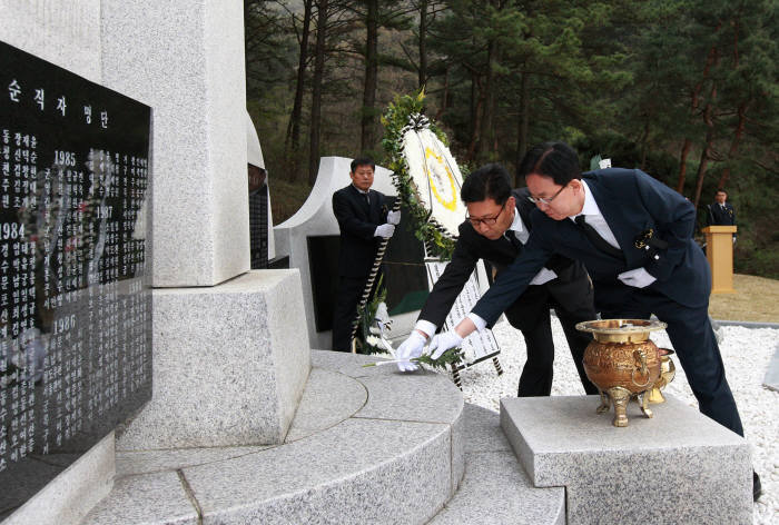 김준호 우정사업본부장(오른쪽)이 순직 우정인 500여명의 이름이 새겨진 추모비에 헌화를 하고 있다