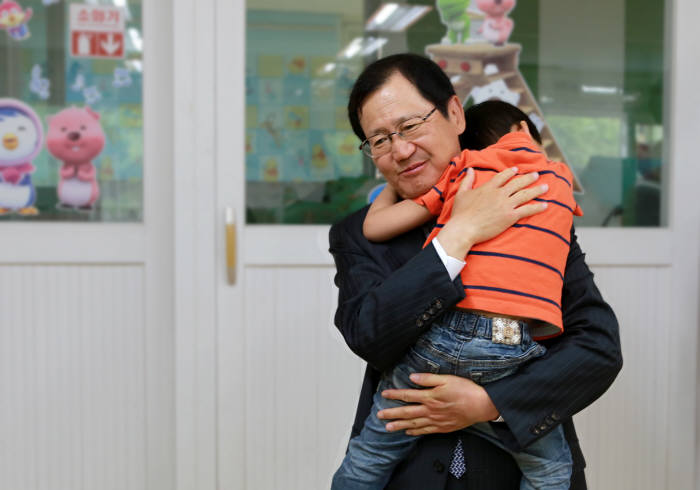 박찬구 금호석유화학 회장이 한사랑장애영아원을 찾아 아이를 안아 위로하고 있다.