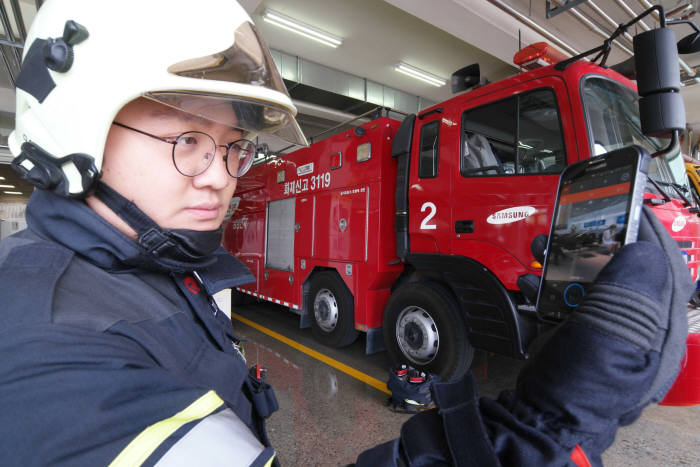 삼성전자 응급 구조대원이 재난망용 스마트폰으로 현장에서 중앙관제소와 통신하고 있다.