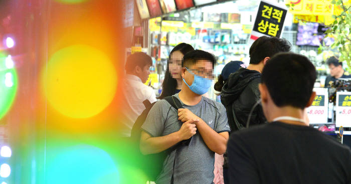 <<위 사진은 본 기사와 관계없음>> 중동호흡기증후군(메르스) 확진 환자가 30명으로 늘어난 3일 서울 용산 전자상가에서 마스크를 쓴 시민이 전자제품을 고르고 있다. 2015.06.03 / 김동욱기자 gphoto@etnews.com