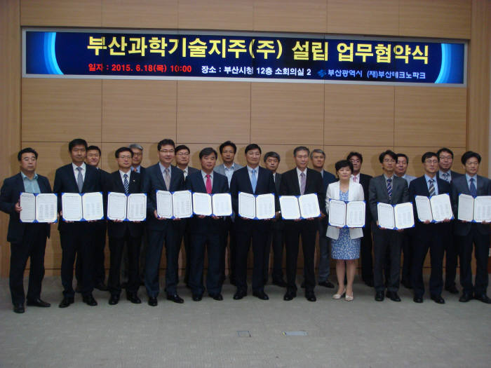 부산시와 부산테크노파크, 부산 16개 대학은 18일 부산시청에서 `부산과학기술지주 설립을 위한 업무협약`을 맺었다. 김규옥 부산시 경제부시장(앞줄 왼쪽 여섯번째)과 김태경 부산TP 원장(다섯번째), 김성옥 한국신발피혁연구원장(일곱번째)이 16개 대학 산학협력단장들과 협약서를 들고 기념촬영했다.