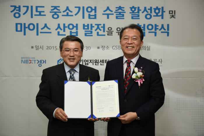 윤성일 경기중기센터 대표(왼쪽)와 홍승표 경기관광공사 사장이 수출활성화와 마이스산업 발전을 위한 협약서를 들고 미소를 짓고 있다.