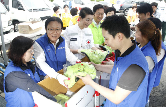 박근희 삼성사회봉사단 부회장, 김성주 대한적십자사 총재, 김주현 사회복지공동모금회 사무총장(왼쪽 두번째부터) 등 관계자들이 21일 서울 신월동 대한적십자사 긴급구호종합센터에서 이재민에게 전달할 응급구호품 세트를 포장하고 있다.
 <삼성 제공>