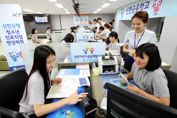 제주여자상업고등학교 학생 24명이 지난 21일 서울 광화문 소재 신한 청소년 금융교육센터를 방문해 실제 영업점과 동일한 환경에서 은행원 업무를 체험하고 있다