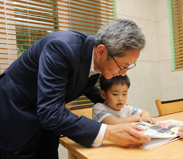 KB국민은행 윤종규 은행장이 `고맙습니다 삼성산 작은 도서관`을 방문한
 아이들에게 책을 읽어주는 모습