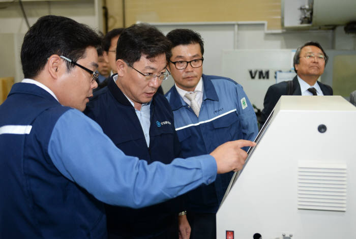 윤상직 산업통상자원부 장관(왼쪽 두번째)이 에이엔텍 관계자로부터 스마트공장 설비에 관해 설명을 듣고 있다.