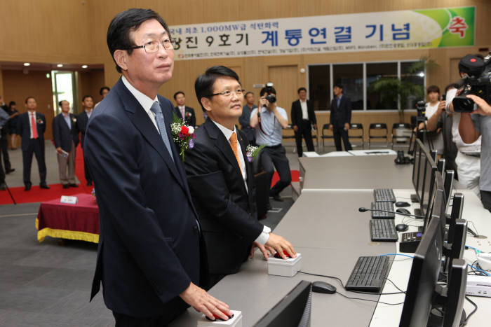 조환익 한국전력 사장(왼쪽)과 장주옥 동서발전 사장이 당진 9호기 계통연결 버튼을 누르고 있다.