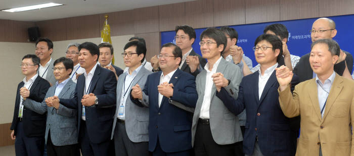 미래창조과학부는 11일 정부과천청사에서 ‘지상파 UHD 방송 표준 방식 협의회’를 발족했다. 최재유 미래부 2차관(앞줄 오른쪽 네 번째)과 참석자가 손을 맞잡고 있다. 박지호기자 jihopress@etnews.com