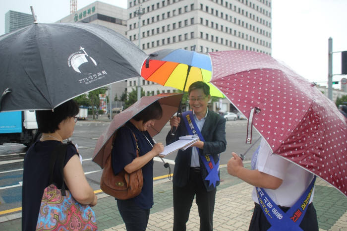 고영회 대한변리사회장이 국회의사당 정문에서 시민들에게 변호사의 변리사 자동자격 폐지를 위한 서명을 받고 있다.