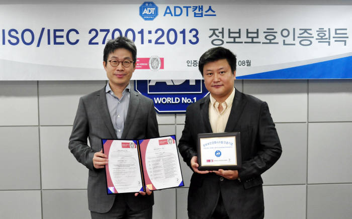 최진환 ADT캡스 대표(왼쪽)와 박병갑 정보보안팀장이 31일 본사 회의실에서 ‘ISO/IEC 27001: 2013’인증 획득 기념촬영을 했다.