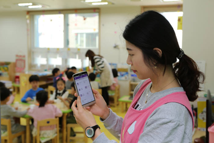 서울 금천 구립 새롬어린이집에서 보육교사가 스마트폰으로 IoT서비스를 시연하고 있는 모습