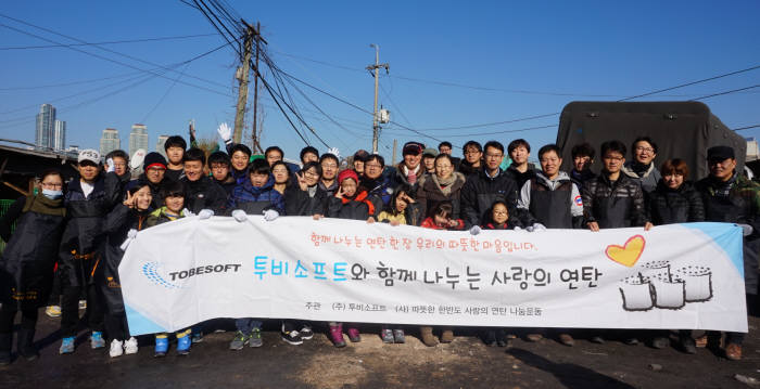 지난 12일 서울 개포동 구룡마을에서 투비소프트 임직원과 가족들이 사랑의 연탄 나르기 행사 후 기념사진을 촬영했다.