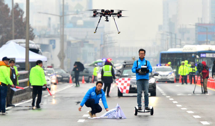 <본 기사와 관련 없음> 29일 서울 영동대교에서 열린 ‘2015 창조경제박람회 미래성장동력 챌린지퍼레이드 자율주행차와 드론 실 도로 시연’ 행사에서 선도비행을 맡은 드론이 하늘로 날아오르고 있다. 울산과학기술원(UNIST) 유니드론팀이 군집비행을 위해 드론을 날리고 있다. / 윤성혁기자 shyoon@etnews.com