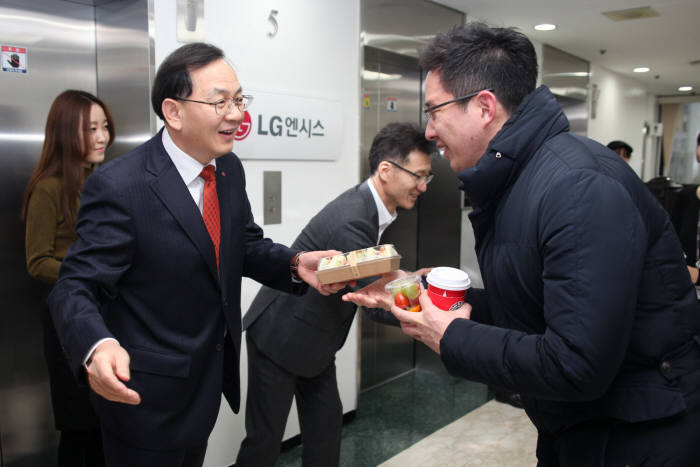 6일 김도현 LG엔시스 대표가 서울 공덕동 본사에서 출근하는 직원에게 샌드위치와 음료를 나눠주고 있다.