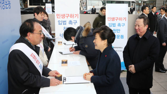 민생구하기 입법촉구 천만 서명 운동. 박근혜 대통령이 1월 18일 오후 경기도 판교 네오트랜스빌딩 앞 광장에 설치된 ‘민생구하기 입법 촉구 천만 서명 운동’ 서명부스를 방문해 국회의 경제활성화 입법을 촉구하는 내용에 서명했다. 박 대통령 뒤는 박용만 대한상의 회장.