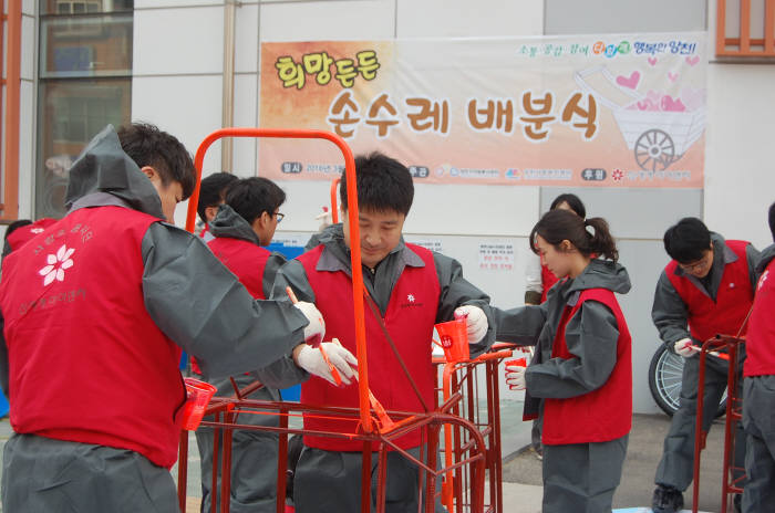 신세계아이앤씨 직원들이 경량화 된 손수레에 형광 페인트로 도색을 하고 있다.