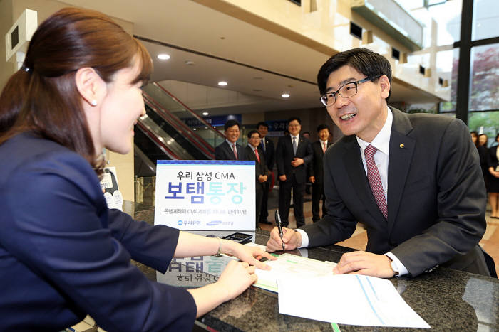 18일 서울 중구 소재 우리은행 본점에서 이광구 은행장이 `우리-삼성CMA보탬통장`에 1호로 가입했다.