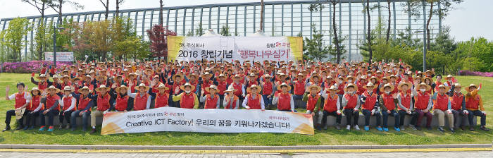 SK주식회사 직원들이 행복나무 심기 행사를 진행한 후 기념사진을 촬영하고 있다.