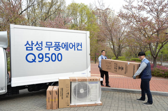 삼성전자 에어컨 전문 설치 기사들이 경기도 고양시 덕이동 한 아파트에서 고객에게 배송할 삼성 무풍에어컨 Q9500을 차량에서 내리고 있다.