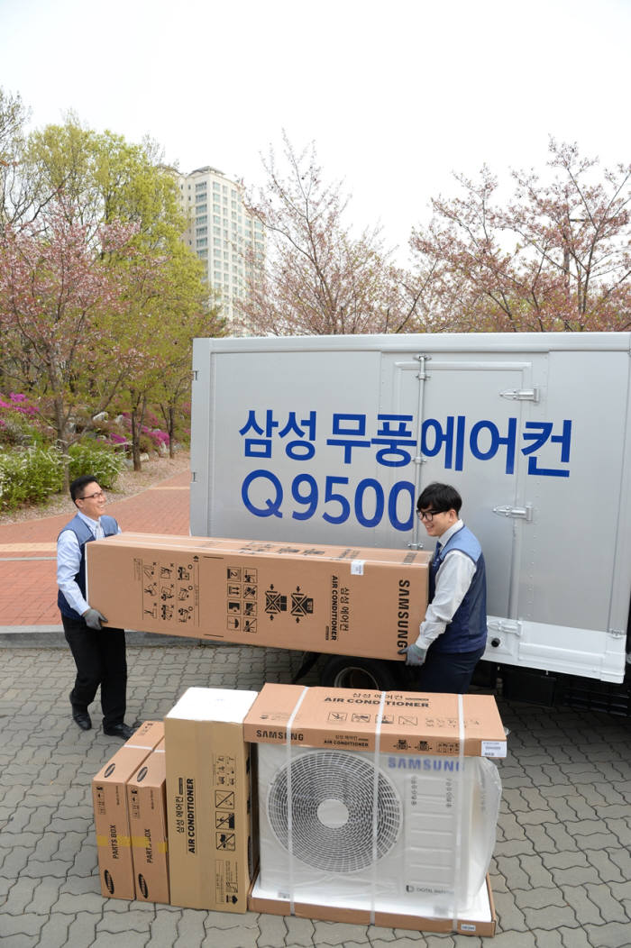 삼성전자 에어컨 전문 설치 기사들이 경기도 고양시 덕이동 한 아파트에서 고객에게 배송할 삼성 무풍에어컨 Q9500을 차량에서 내리고 있다.