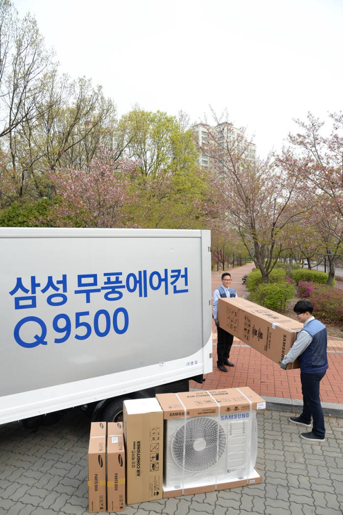 삼성전자 에어컨 전문 설치 기사들이 경기도 고양시 덕이동 한 아파트에서 고객에게 배송할 삼성 무풍에어컨 Q9500을 차량에서 내리고 있다.