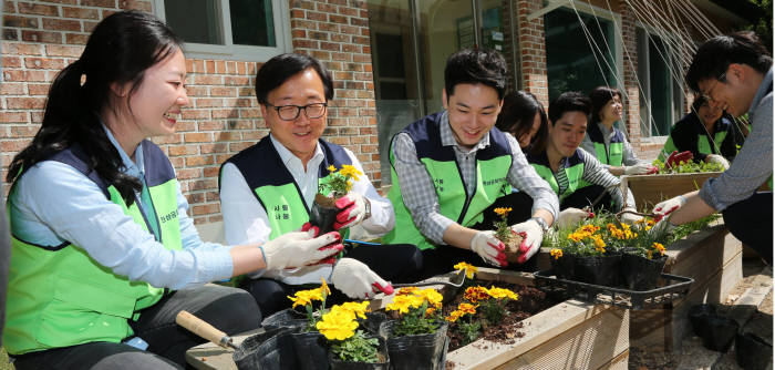 이동근 대한상공회의소 상근부회장(왼쪽 두번째)을 비롯한 대한상의 사랑나눔 봉사단이 남산원 화단에 꽃을 심고 있다.