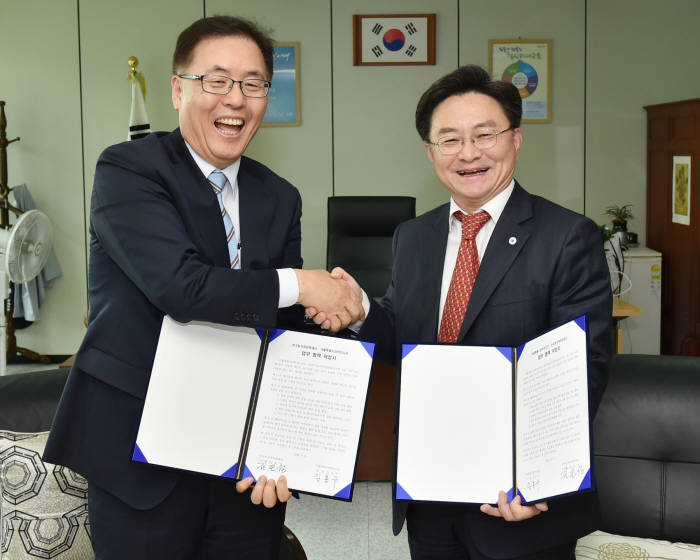 김호성 원자력문화재단 이사장(오른쪽)이 임용우 서울시과학전시관 관장과 협약서를 교환한 뒤 활짝 웃고 있다.