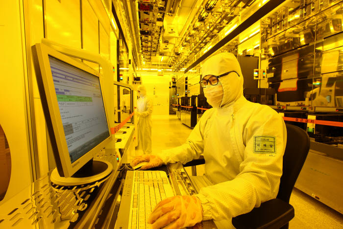 삼성전자 반도체 생산공장에서 한 연구원이 공정 진행과정을 모니터로 살펴보고 있다.
