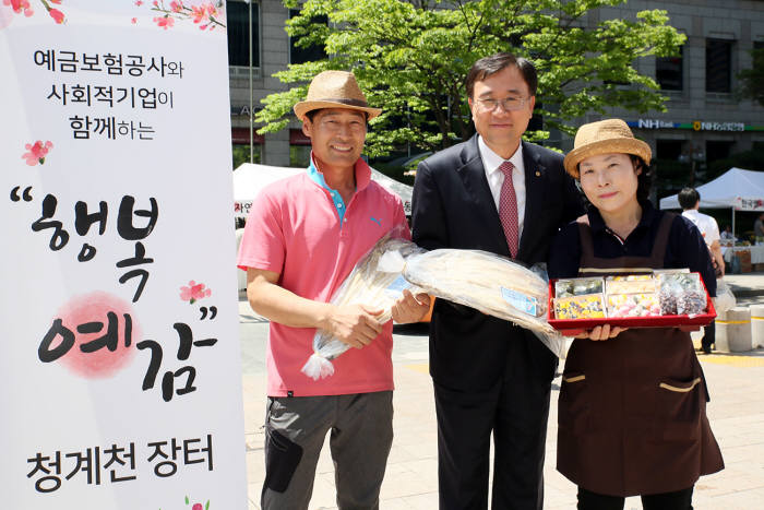 예금보험공사는 18일 서울 중구 청계천 광통교에서 동반성장을 위한 `행복예감 청계천장터`를 개최했다. 곽범국 예금보험공사 사장(가운데)이 장터에 참여한 사회적기업 판매자들과 기념 촬영했다.