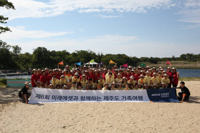 제6회 미래에셋과 함께하는 제주도 가족여행에 참가한 초등학생과 조부모가 제주도 에코랜드 테마파크에서 기념촬영을 하고 있다.